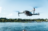 black DJI Mavi quadcopter near body of water