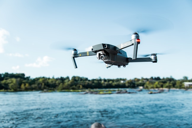 black DJI Mavi quadcopter near body of water