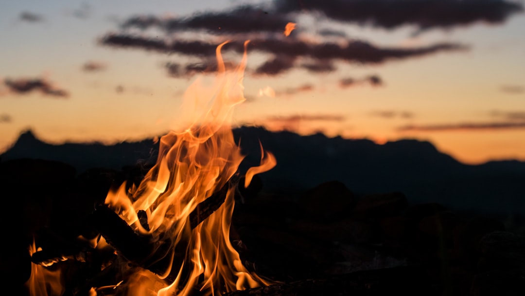 bonfire overlooking silhouette of mountain golden hour photography