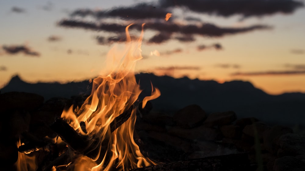 山のシルエットを見下ろす焚き火ゴールデンアワー写真