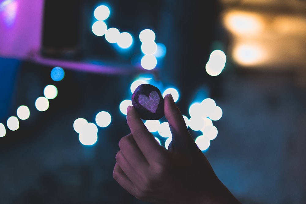 selective focus photography of person holding cookie