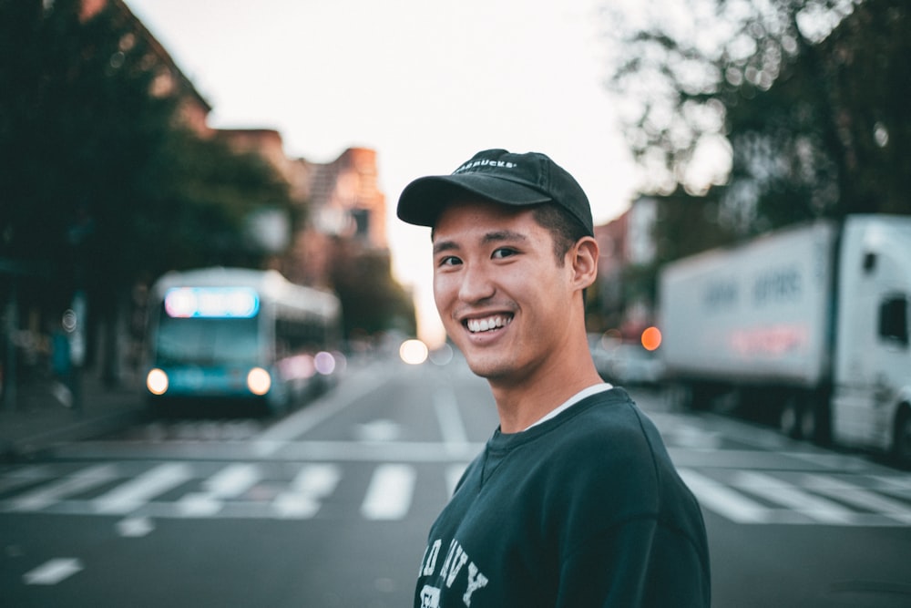 man stranding on straight road photo during daytime