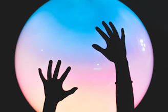 Close-up of hands gently releasing glowing energy particles into the air, symbolizing emotional freedom.