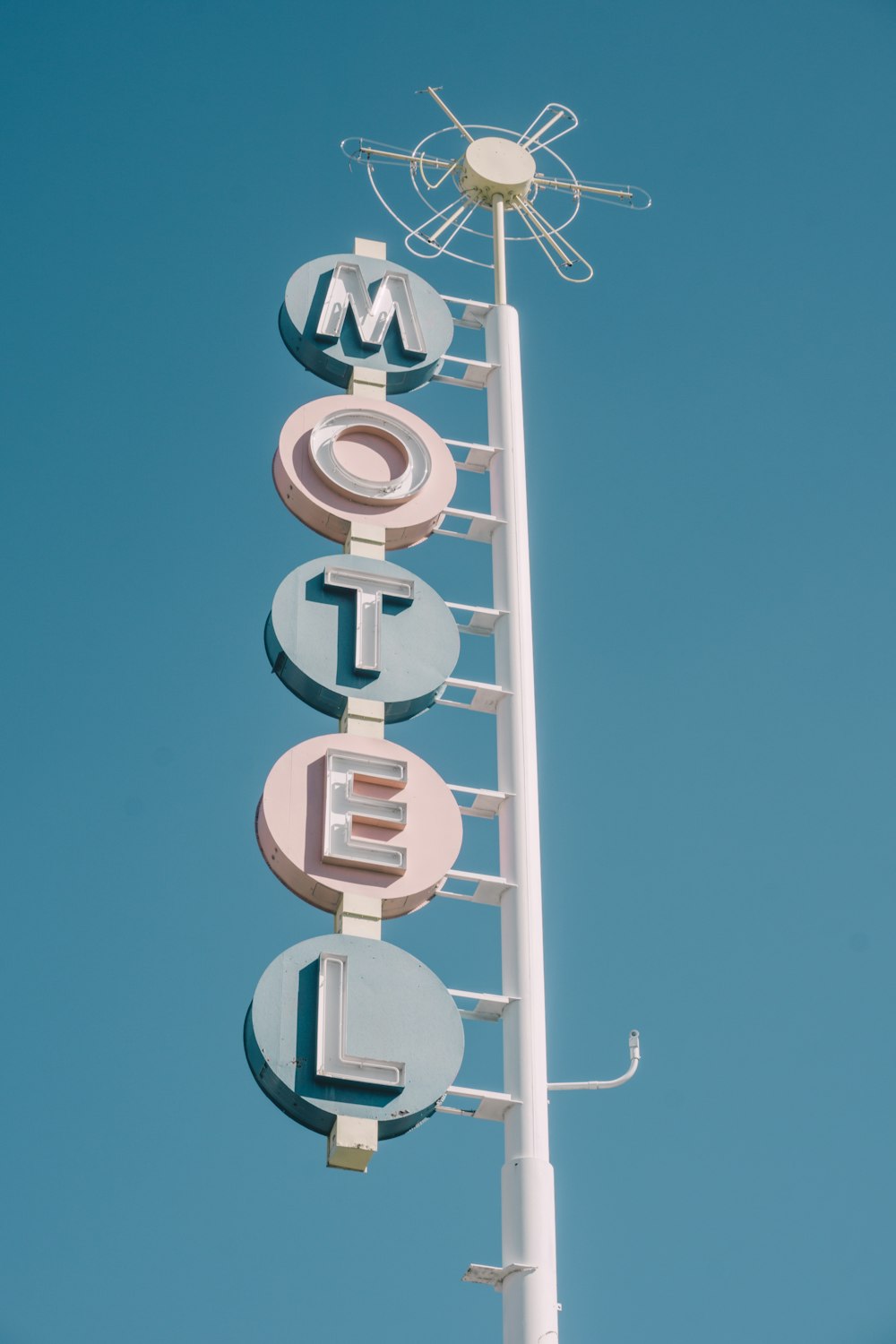 white and teal metal motel signage