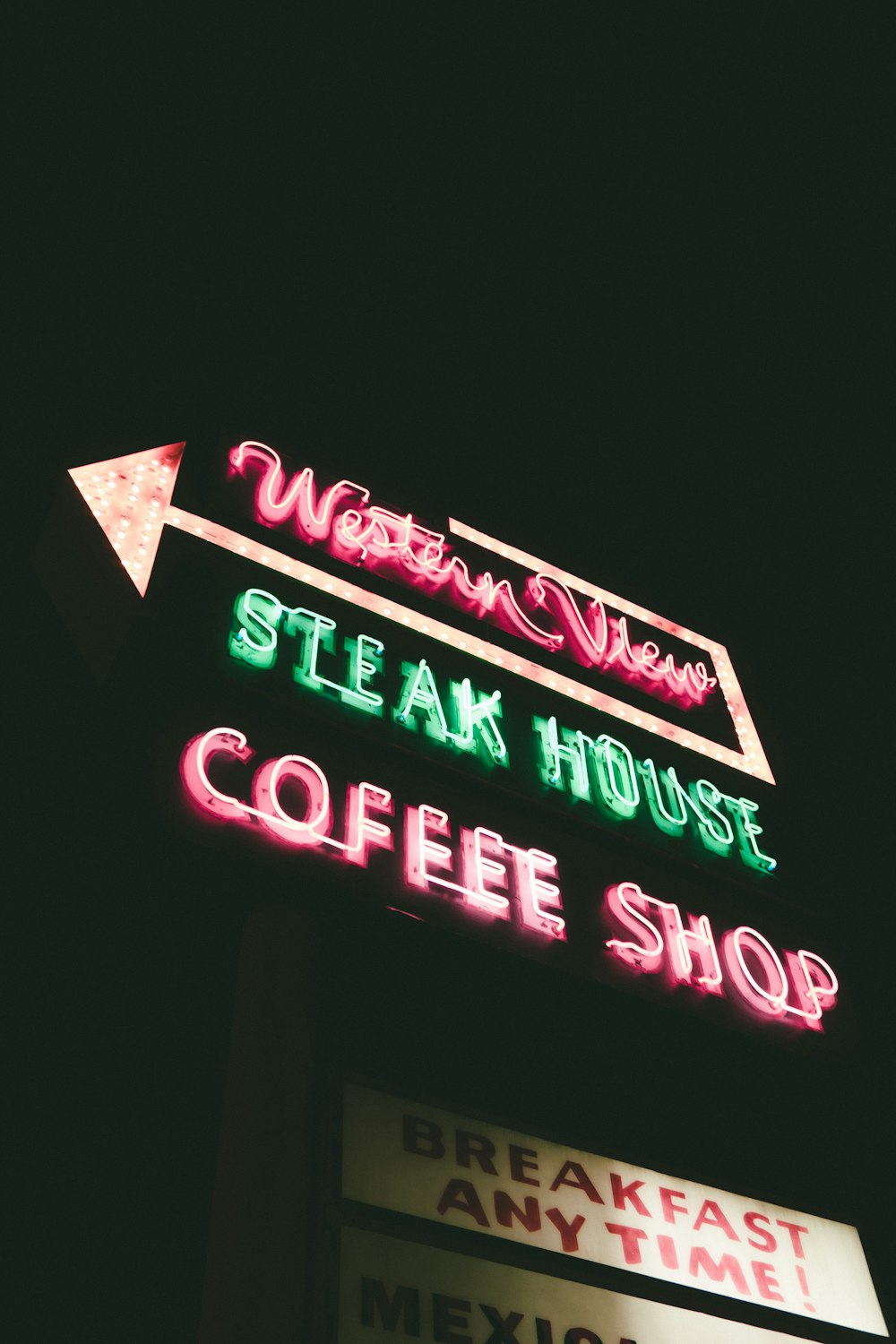 웨스턴 뷰 스테이크 하우스 커피 숍 네온 사인의 로우 앵글 사진 밤에 켜짐