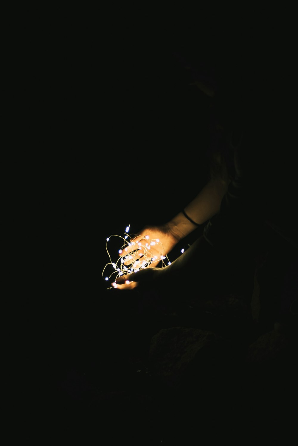 person holding string lights