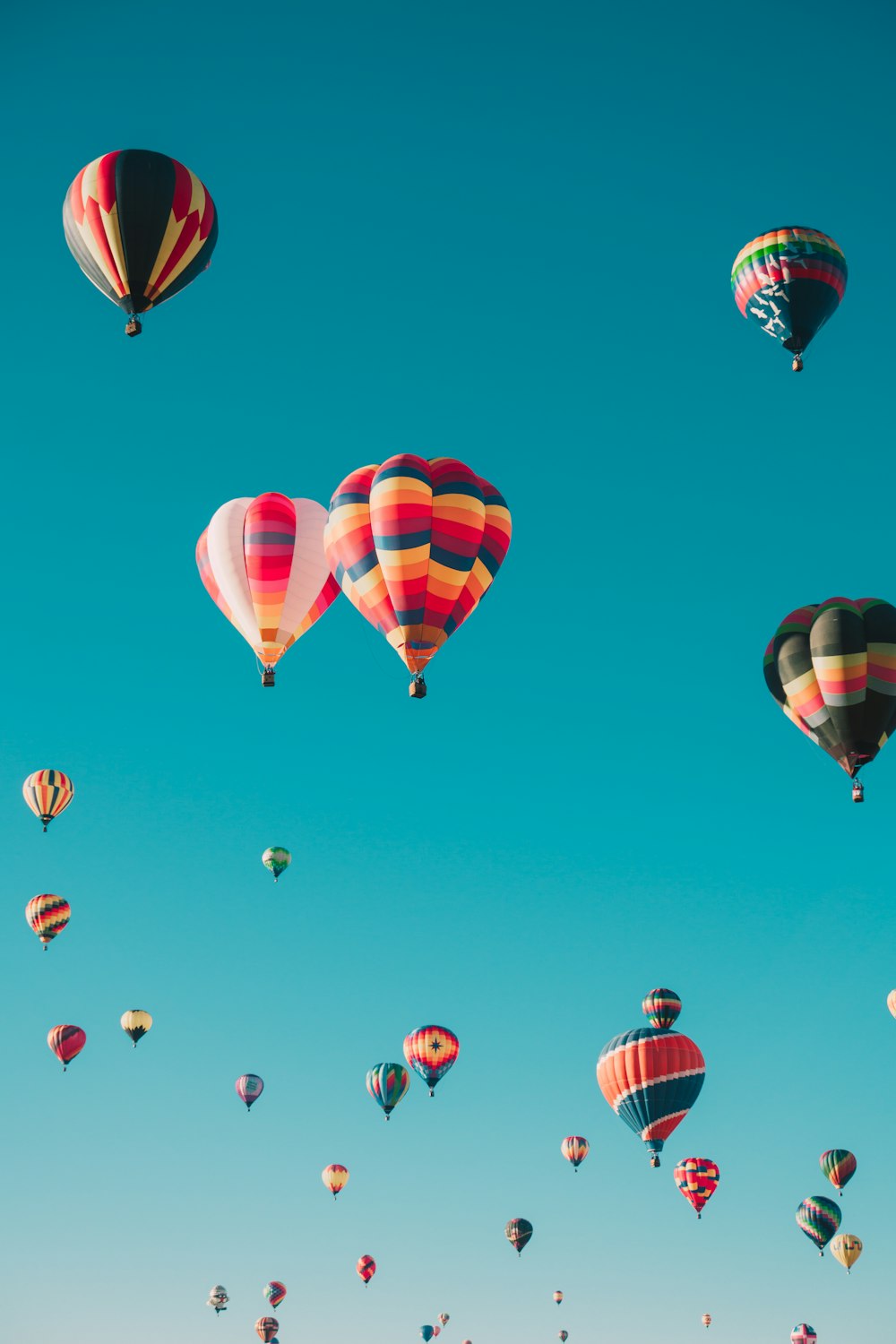 verschiedene Heißluftballons, die tagsüber in großer Höhe fliegen