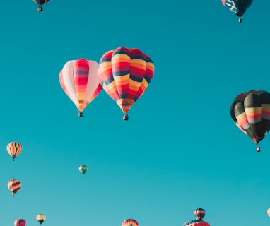 assorted hot air balloons flying at high altitude during daytime