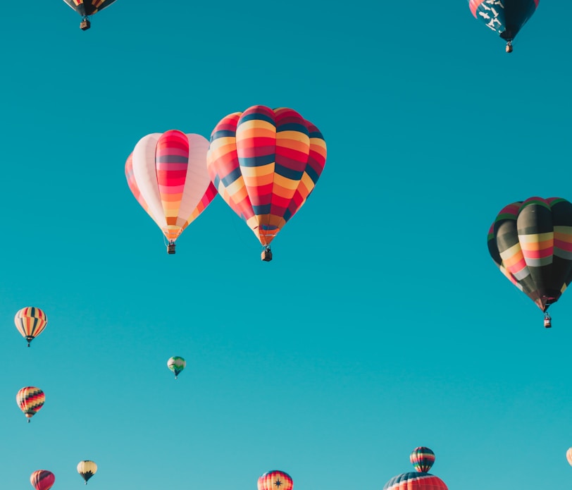 assorted hot air balloons flying at high altitude during daytime