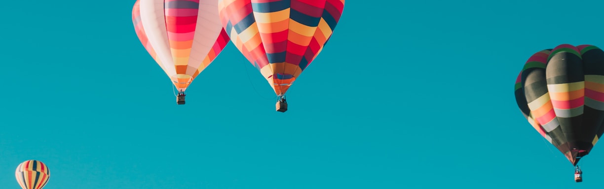 assorted hot air balloons flying at high altitude during daytime