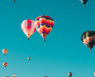 assorted hot air balloons flying at high altitude during daytime