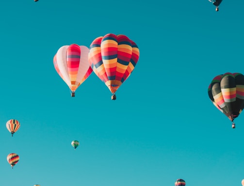 assorted hot air balloons flying at high altitude during daytime