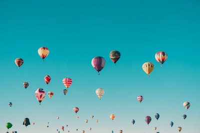 Hot air balloons of every colour in a blue sky