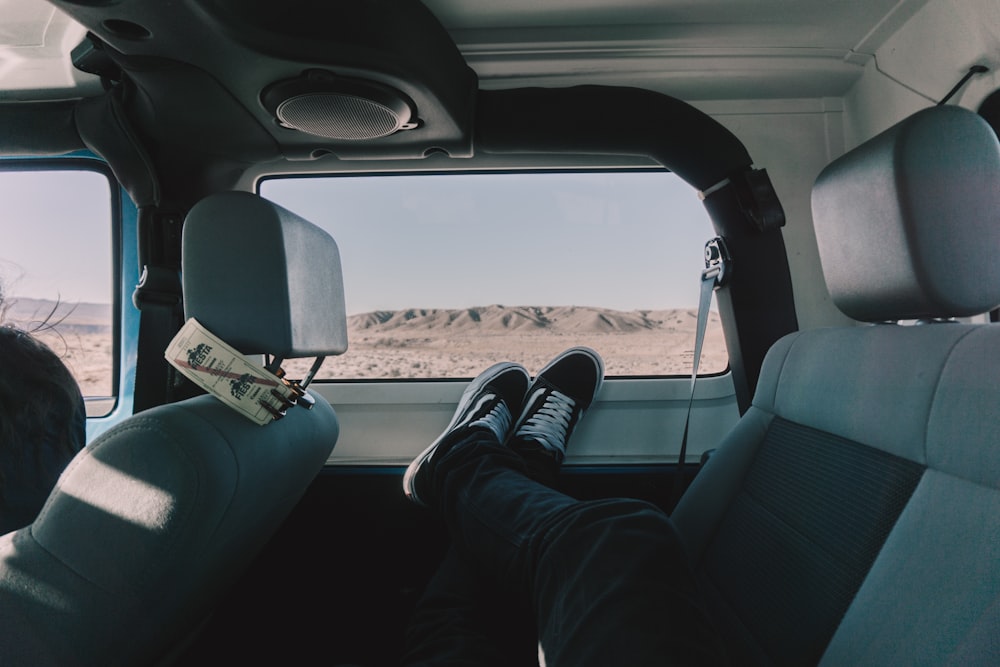 person's both feet on vehicle window