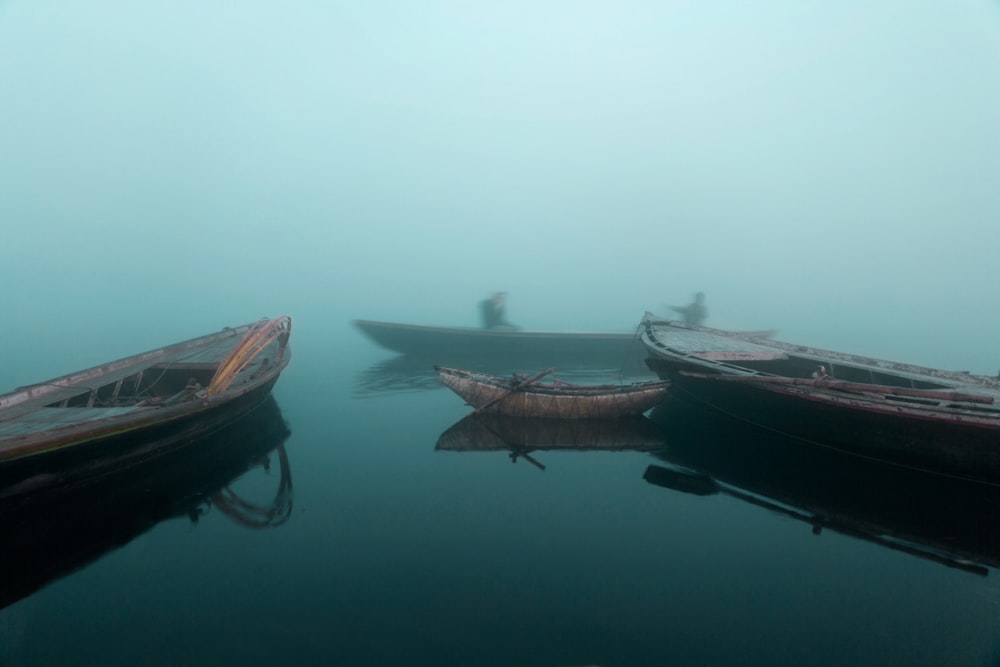 panning photo of four brown boats