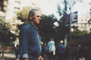 Dennis walking outdoors, the city skyline blurred in the background, reflecting on his treatment.