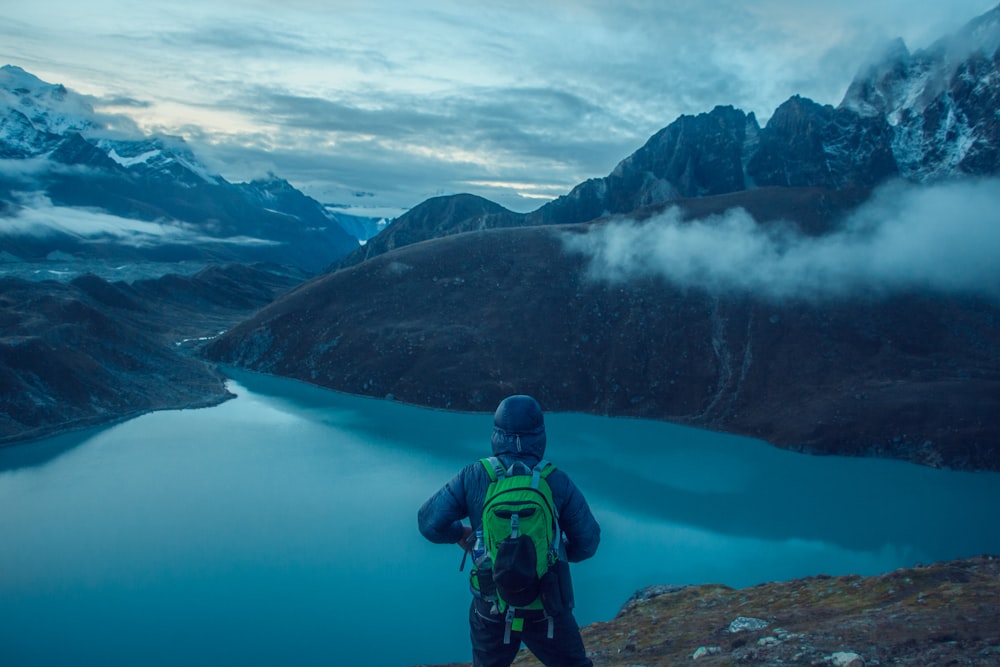 Persona di fronte al lago circondata da montagne foto