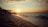 A serene beach at sunset, symbolizing romance and new beginnings, with gentle waves lapping at the shore.