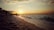 A serene beach at sunset, symbolizing romance and new beginnings, with gentle waves lapping at the shore.