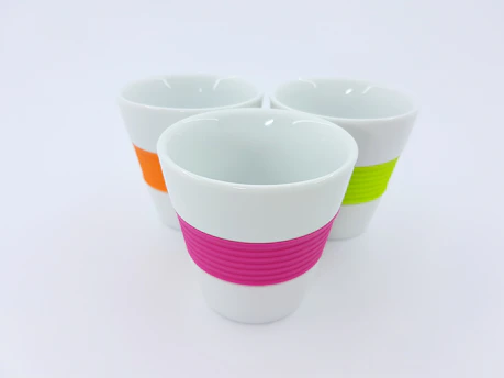 A colorful set of insulated travel cups arranged neatly on a shelf