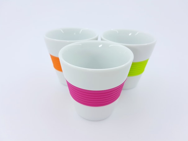 A set of customized coffee cups featuring sharp, modern designs in purple and white accents