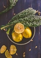 sliced lemon and green leaves on gray stainless steel bowl