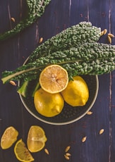 sliced lemon and green leaves on gray stainless steel bowl