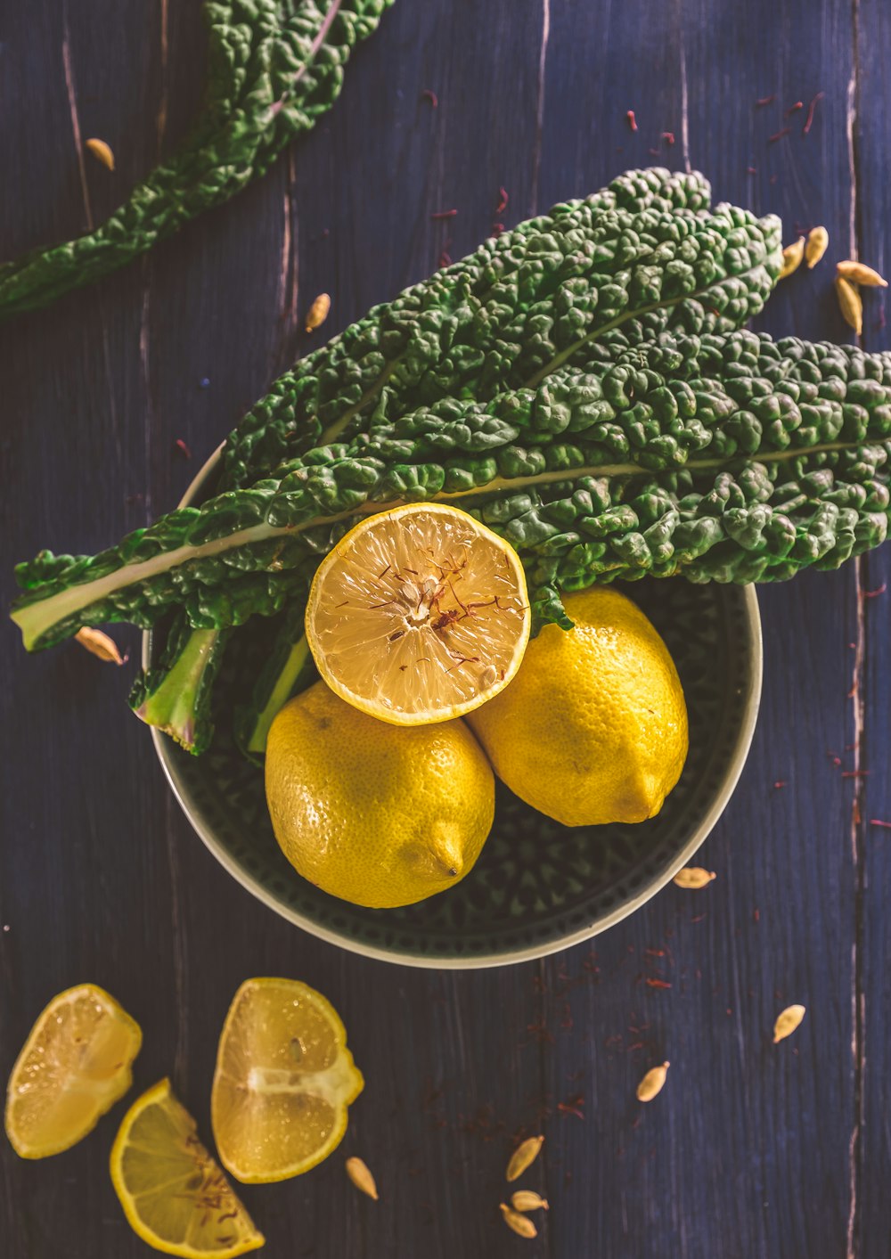 sliced lemon and green leaves on gray stainless steel bowl