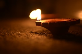 Close-up of a traditional oil lamp flickering gently during evening aarti.
