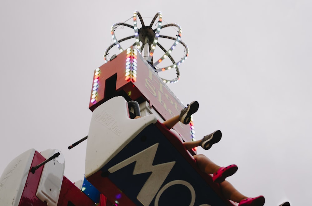 photo of person sitting on ride at amusement park