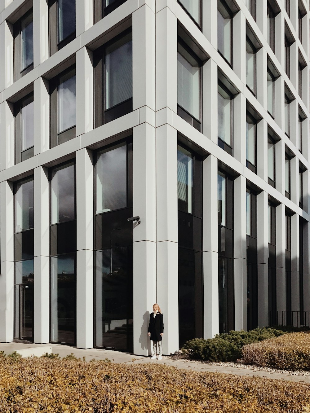 woman wearing black dress standing near building