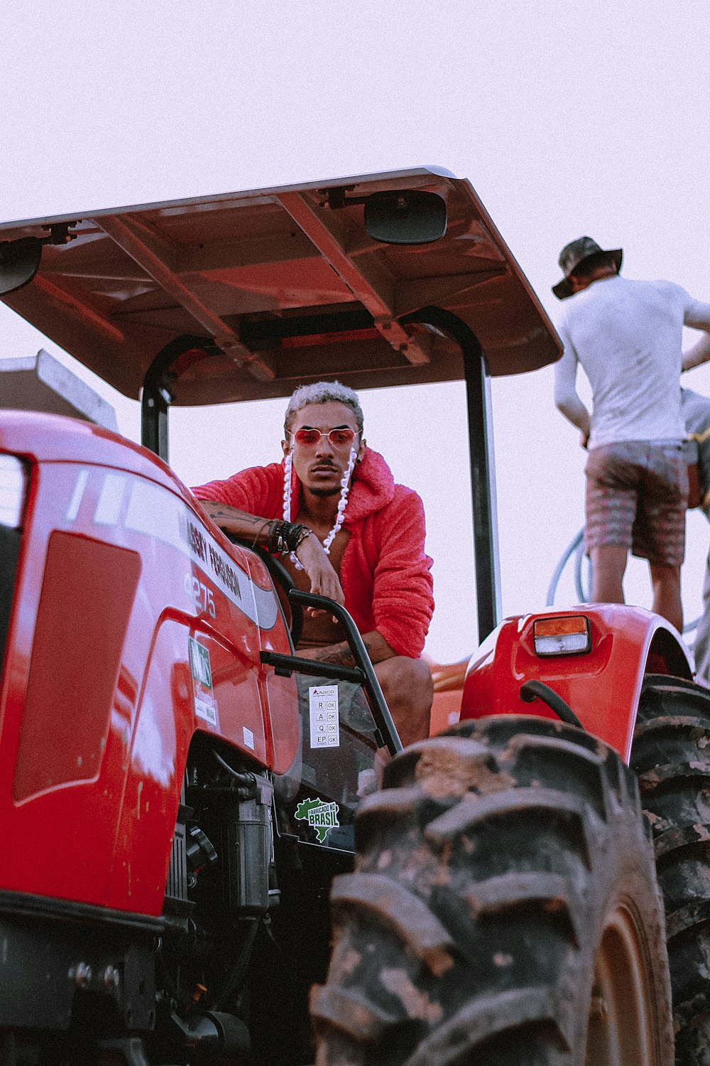 man riding red tractor