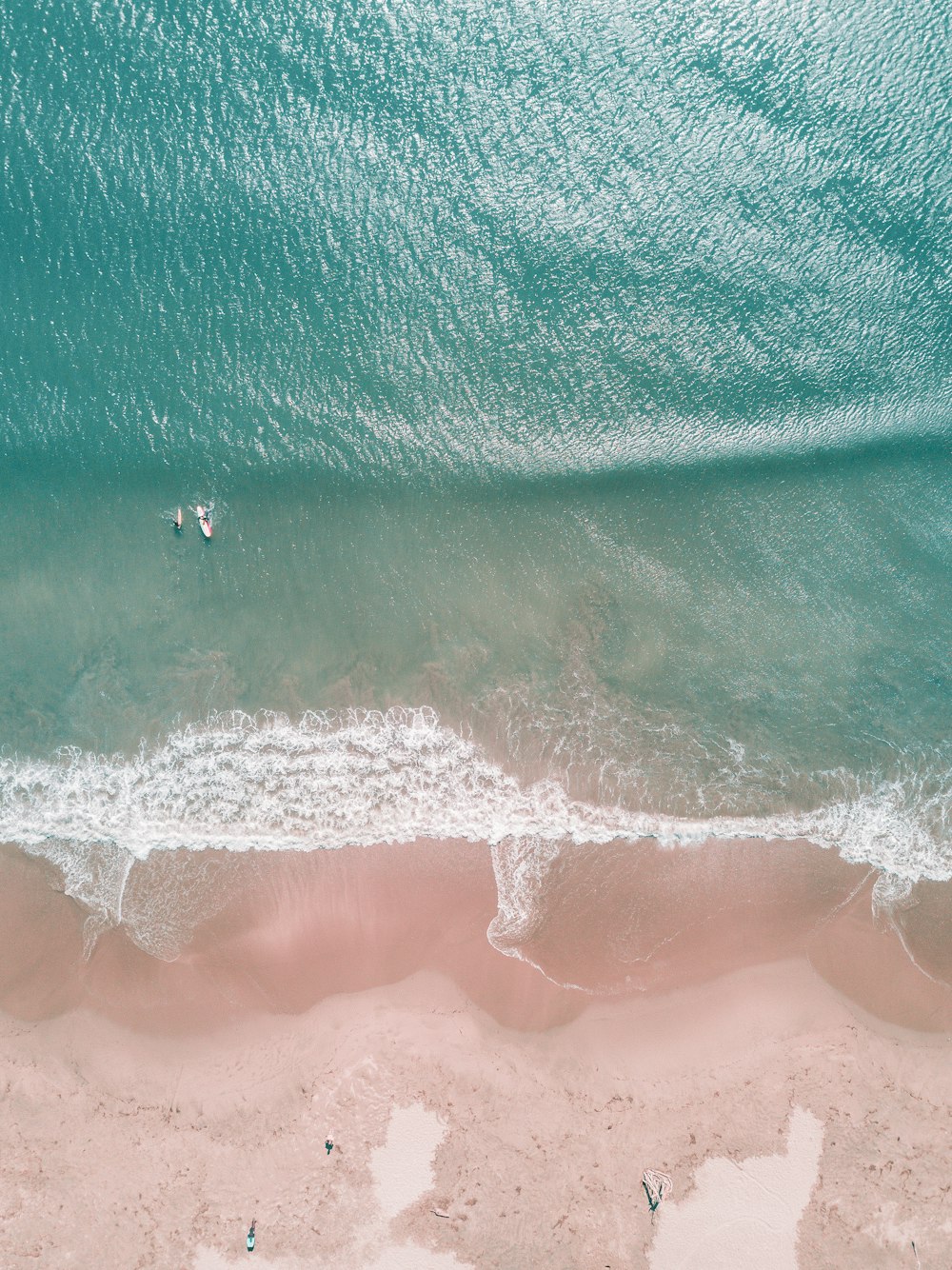 Fotografía aérea de personas surfeando en la orilla del mar durante el día