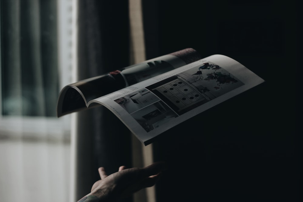 person throwing opened book in room