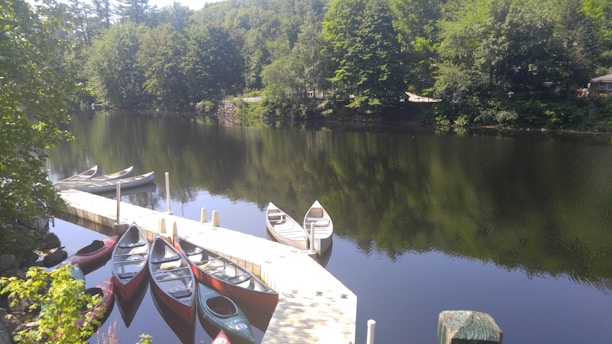 A serene view of the Rum River with canoes gently floating on the water under a clear blue sky.