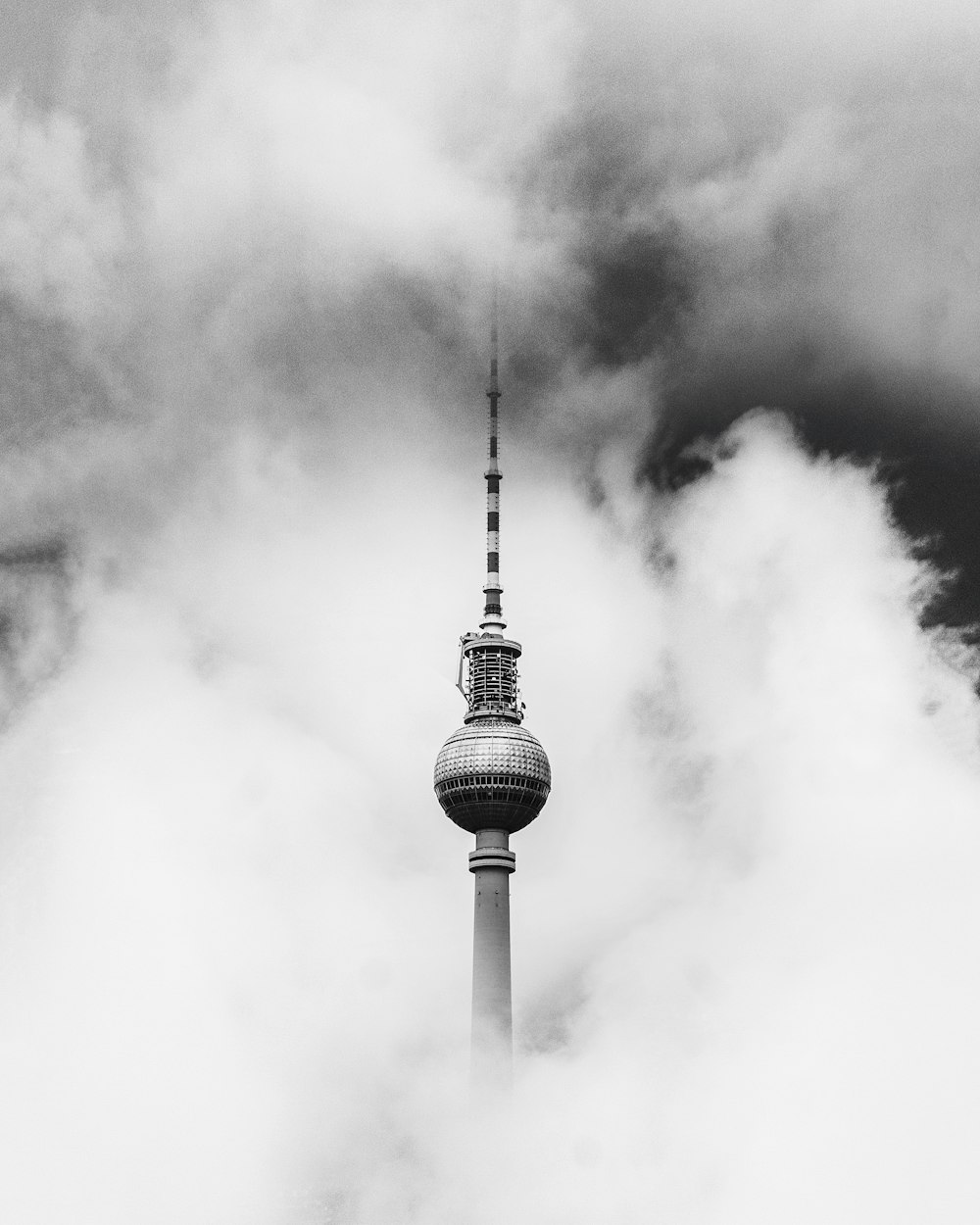 greyscale photo of tower covered in smoke