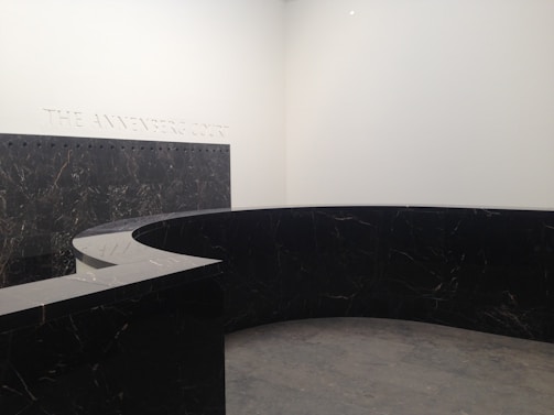 A book-matched marble floor with striking veining, showcased in a minimalist, high-ceilinged foyer.