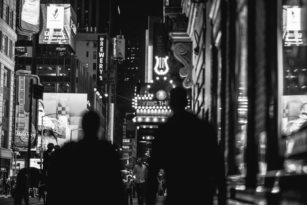 grayscale photo of two person standing on hallway