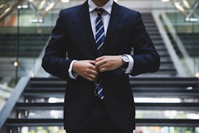 finance business man from a gold ira company standing in front of stairs with suit on