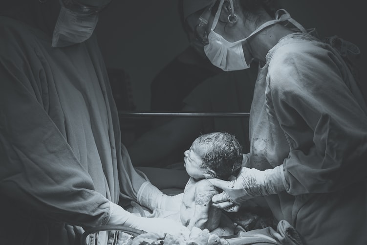 A baby being delivered by C-section.^[[Image](https://unsplash.com/photos/-P2djqAwM8U) by [Patricia Prudente](https://unsplash.com/@apsprudente) on [Unsplash](https://unsplash.com/)]