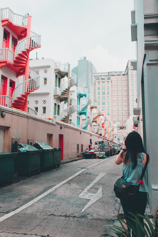 woman wearing green shirt standing near green grass during daytime in Bugis Street Singapore