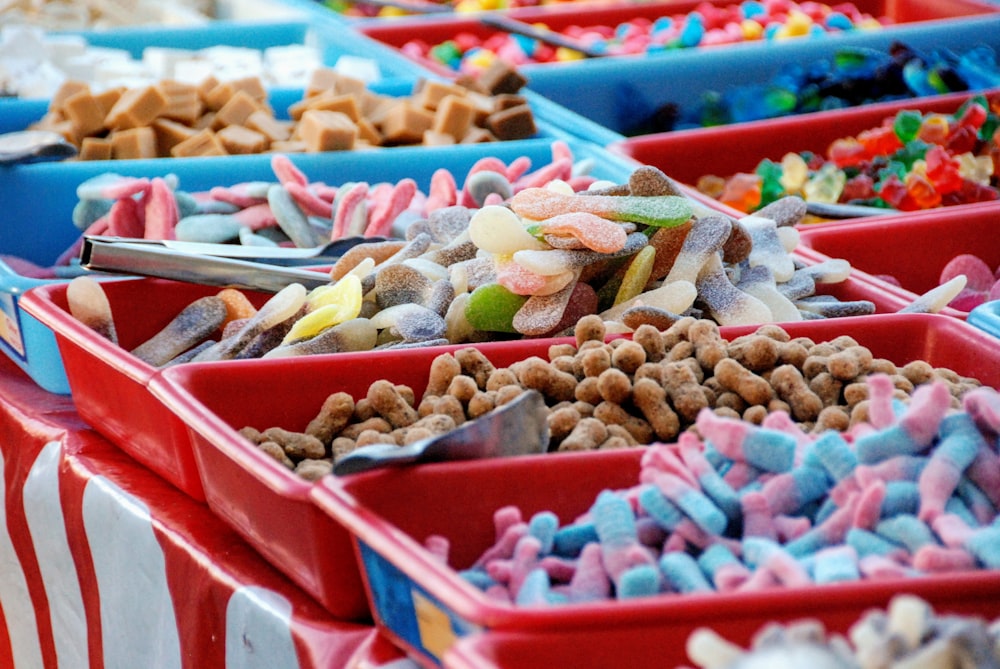 Friandises sucrées de couleurs assorties dans des barquettes en plastique rouge et bleu