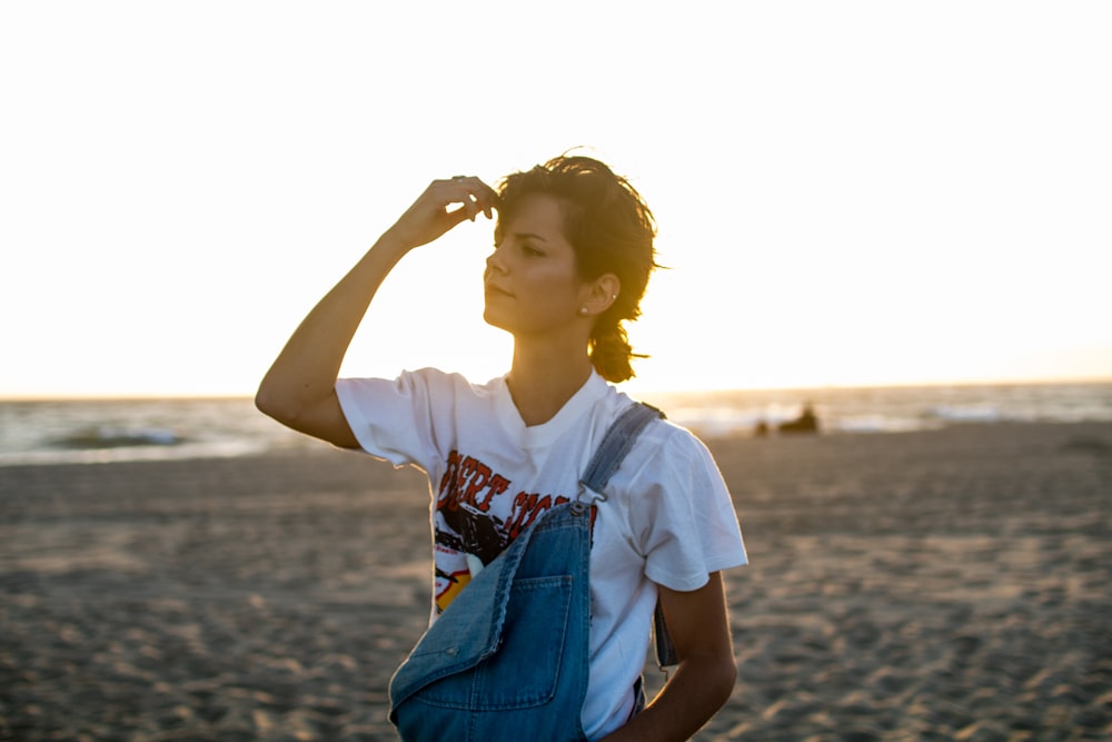 woman standing on seashore holding her head