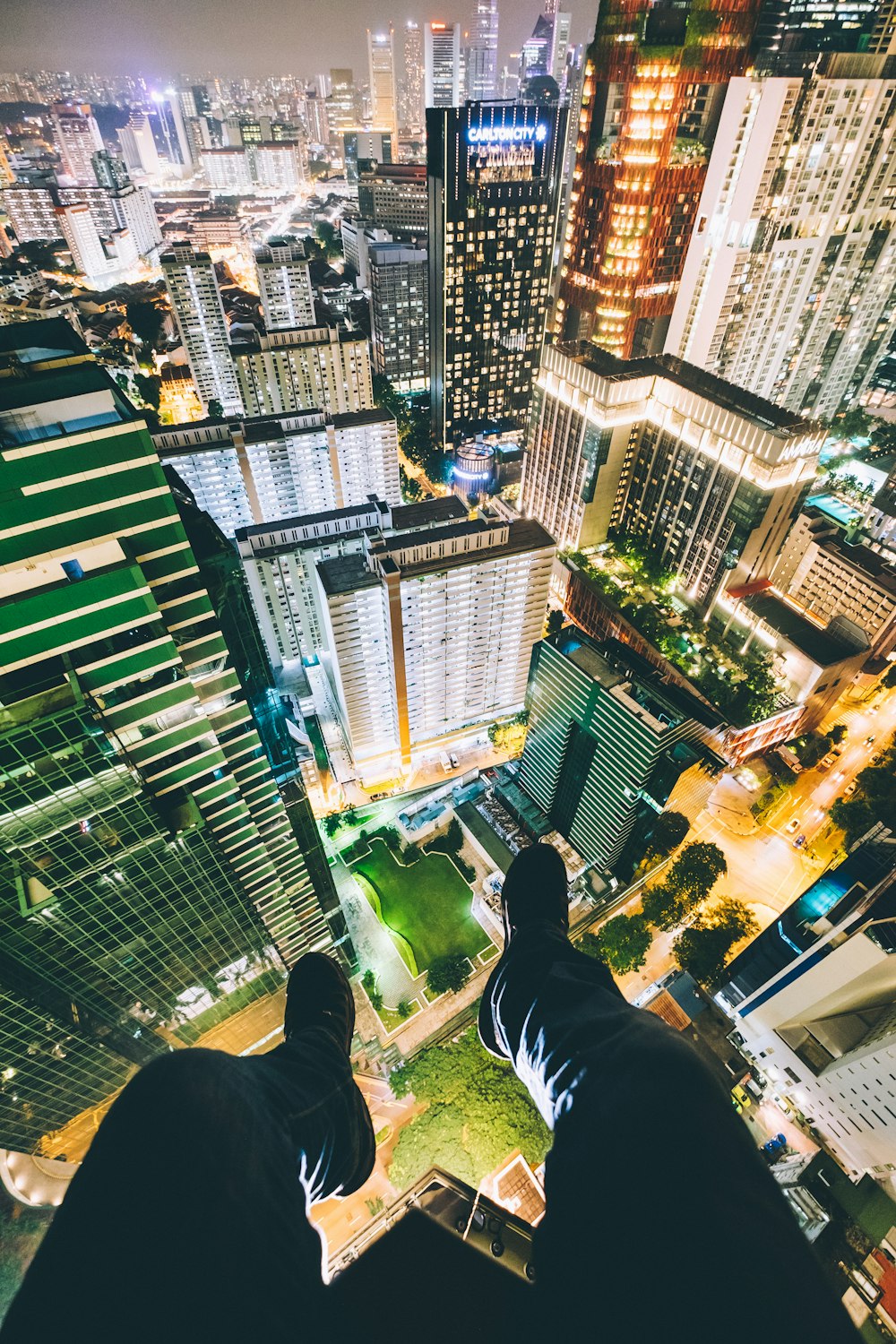 man sitting on top of high-rise buildings