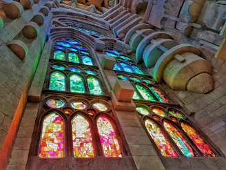 A warm, inviting collage of ancient stained glass windows glowing with vibrant historical hues.