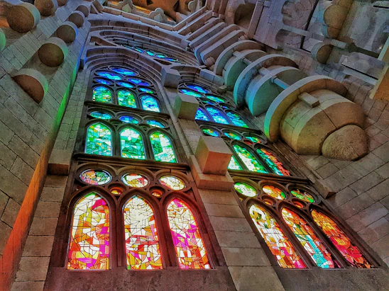 A warm, inviting collage of ancient stained glass windows glowing with vibrant historical hues.