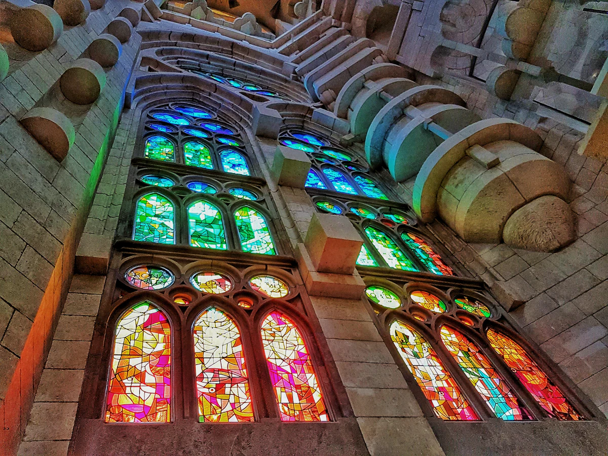 Coloured light from stained glass windows flooding the interior of the Sagrada Família