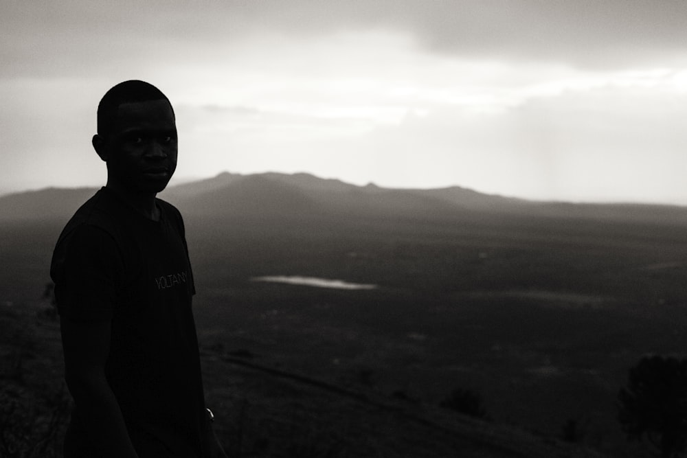 Junge steht während eines nebligen Tages auf einem kahlen Hügel