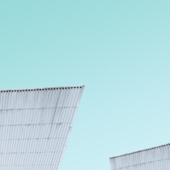 A sleek steel cabin structure under construction against a clear sky.
