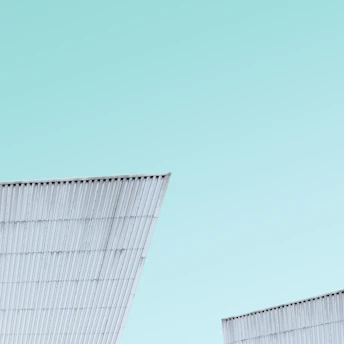 A sleek, modern prefabricated steel house set against a clear blue sky.